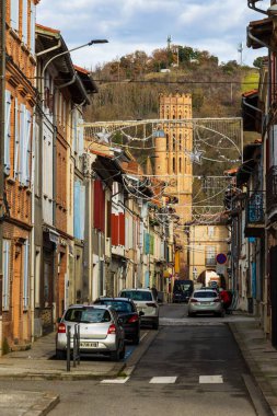 Rue Mages 'dan Montesquieu-Volvestre' nin merkezindeki Saint Victor Kilisesi 'nin kırmızı çan kulesine doğru görüş.