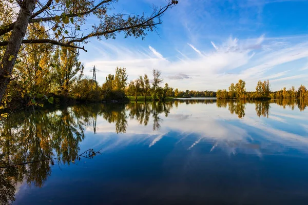 Uzun vadede Sabatouse Gölü 'nün sakin sularındaki sonbahar ağaçlarının yansımaları.