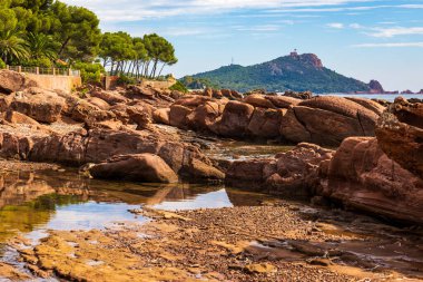 Cap Dramont ufukta, semaforuyla Saint-Raphael 'in kızıl kayalık kıyılarından görülüyor.