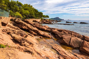Cap Dramont ufukta, semaforuyla Saint-Raphael 'in kızıl kayalık kıyılarından görülüyor.