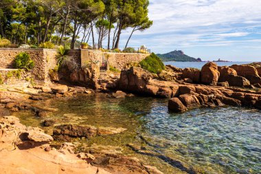 Cap Dramont ufukta, semaforuyla Saint-Raphael 'in kızıl kayalık kıyılarından görülüyor.
