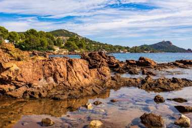 Cap Dramont ufukta, semaforuyla Saint-Raphael 'in kızıl kayalık kıyılarından görülüyor.