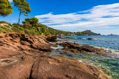 Cap Dramont ufukta, semaforuyla Saint-Raphael 'in kızıl kayalık kıyılarından görülüyor.