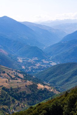 Col d Aspin 'teki yemyeşil Aure Vadisi' nin panoramik manzarası. Pyrenean tepeleri ufku oluşturur.