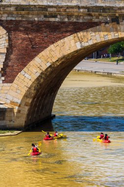 Toulouse 'daki Pont Neuf' un altından geçen Garonne Nehri 'ndeki kayakçılar