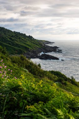 Cape Higuer 'in etrafındaki Jaizkibel Dağı' nın eteğinde Bulutlu Gök Altında Rocky Sahili