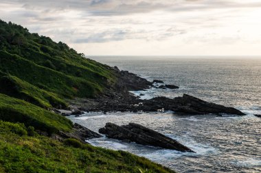 Cape Higuer 'in etrafındaki Jaizkibel Dağı' nın eteğinde Bulutlu Gök Altında Rocky Sahili