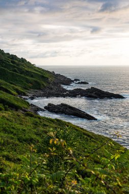 Cape Higuer 'in etrafındaki Jaizkibel Dağı' nın eteğinde Bulutlu Gök Altında Rocky Sahili