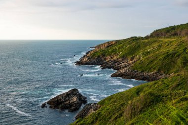 Cape Higuer 'in etrafındaki Jaizkibel Dağı' nın eteğinde Bulutlu Gök Altında Rocky Sahili