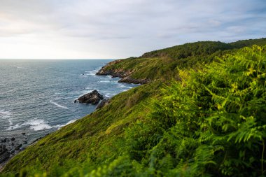 Cape Higuer 'in etrafındaki Jaizkibel Dağı' nın eteğinde Bulutlu Gök Altında Rocky Sahili