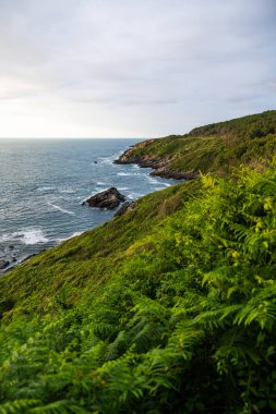 Cape Higuer 'in etrafındaki Jaizkibel Dağı' nın eteğinde Bulutlu Gök Altında Rocky Sahili