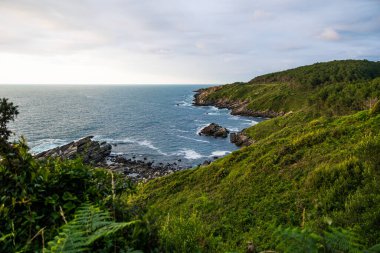 Cape Higuer 'in etrafındaki Jaizkibel Dağı' nın eteğinde Bulutlu Gök Altında Rocky Sahili