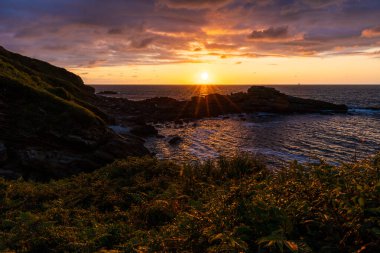 Cantabrian Denizi 'nde Günbatımı Rocky Sahili' nden Jaizkibel Dağı 'nın eteklerindeki Higuer Burnu' nun etrafındaki