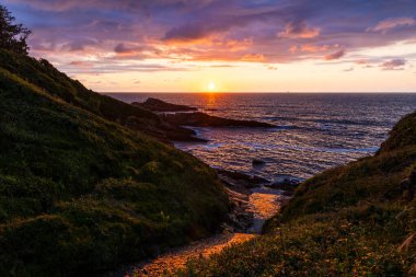 Cantabrian Denizi 'nde Günbatımı Rocky Sahili' nden Jaizkibel Dağı 'nın eteklerindeki Higuer Burnu' nun etrafındaki