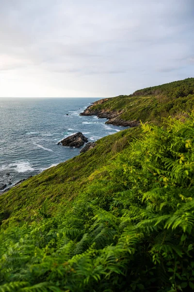 Cape Higuer 'in etrafındaki Jaizkibel Dağı' nın eteğinde Bulutlu Gök Altında Rocky Sahili