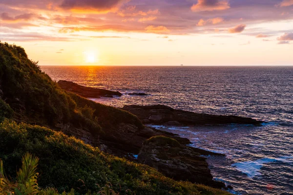 Cantabrian Denizi 'nde Günbatımı Rocky Sahili' nden Jaizkibel Dağı 'nın eteklerindeki Higuer Burnu' nun etrafındaki