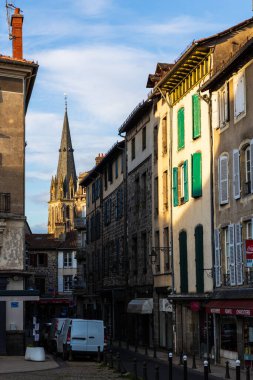 Saint-Geraud manastır kilisesinin çan kulesi şehir merkezinin sokaklarından gün batımında