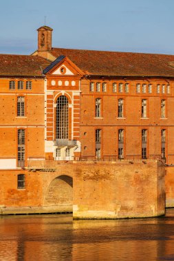 Toulouse 'daki Hotel-Dieu Saint-Jacques' ın cephesi, UNESCO Dünya Mirasları listesine işlenmiş bir anıt, sabah ışığı altında Garonne rıhtımlarından görülüyor.