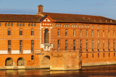 Toulouse 'daki Hotel-Dieu Saint-Jacques' ın cephesi, UNESCO Dünya Mirasları listesine işlenmiş bir anıt, sabah ışığı altında Garonne rıhtımlarından görülüyor.
