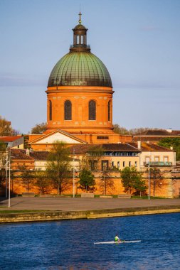 Kürekçiler sandallarında, Toulouse 'daki Garonne' da Saint-Joseph de la Grave Şapeli 'nin önündeki kubbede geziniyorlar.