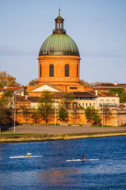 İki kürekçi, Toulouse 'daki Garonne' da Saint-Joseph de la Grave Şapeli 'nin önündeki kubbede geziniyorlar.