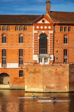 İki kürekçi sandallarıyla Toulouse 'daki Saint-Jacques Oteli' nin önündeki Garonne 'da yol alıyorlar.