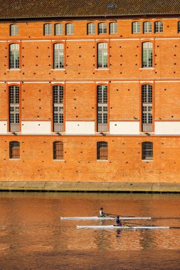 İki kürekçi sandallarıyla Toulouse 'daki Saint-Jacques Oteli' nin önündeki Garonne 'da yol alıyorlar.