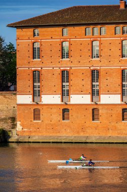 İki kürekçi sandallarıyla Toulouse 'daki Saint-Jacques Oteli' nin önündeki Garonne 'da yol alıyorlar.