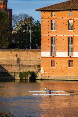 İki kürekçi sandallarıyla Toulouse 'daki Saint-Jacques Oteli' nin önündeki Garonne 'da yol alıyorlar.
