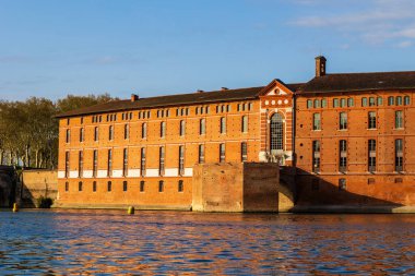 Toulouse 'daki Saint-Jacques Oteli' nin cephesinde UNESCO Dünya Mirasları listesine işlenmiş bir anıt sabah ışığı altında Garonne nehrinin sularına yansıyor.