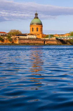 Saint-Joseph de la Grave Kilisesi 'nin kubbesi Toulouse' daki Garonne nehrinin sularına sabah ışığı altında yansıyor.
