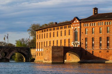 Toulouse 'daki Saint-Jacques Oteli' nin cephesinde UNESCO Dünya Mirasları listesine işlenmiş bir anıt sabah ışığı altında Garonne nehrinin sularına yansıyor.