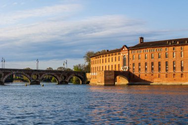 Toulouse 'daki Saint-Jacques Oteli' nin cephesinde UNESCO Dünya Mirasları listesine işlenmiş bir anıt sabah ışığı altında Garonne nehrinin sularına yansıyor.