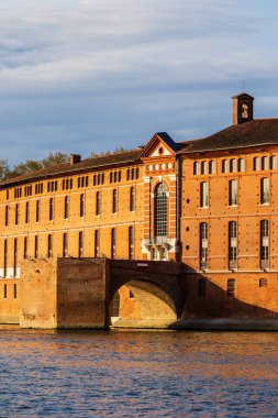 Toulouse 'daki Saint-Jacques Oteli' nin cephesinde UNESCO Dünya Mirasları listesine işlenmiş bir anıt sabah ışığı altında Garonne nehrinin sularına yansıyor.