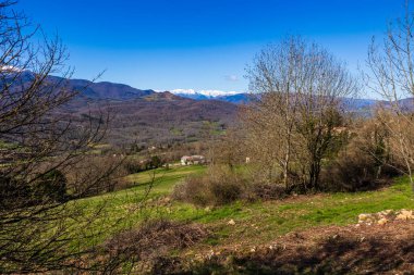 Ufukta Pic des Trois Seigneurs Panoraması ve baharda Ariege Roquefixade köyünden Douctouyre Vadisi görünüyor.
