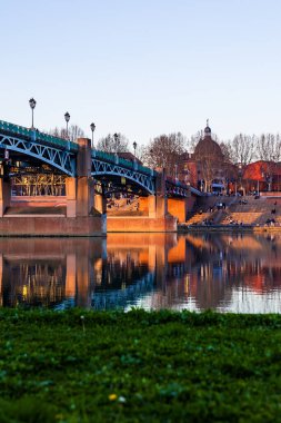 Saint-Pierre Köprüsü Toulouse 'da Sunset' te Garonne Nehri 'nin sularını yansıtıyor.