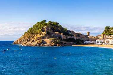 Duvarları ve kuleleri kumsaldan görünen eski Tossa de Mar kasabası.