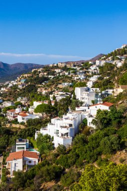 İspanya 'nın Costa Brava kentindeki Roses şehrinde Castell de la Trinitat' tan kayalıklara tünemiş villalar ve binalar.