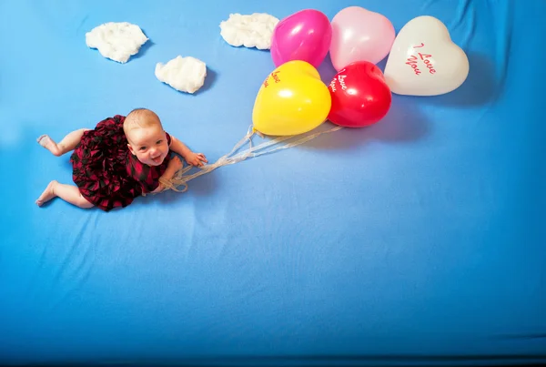 Dziecko leci na balony w chmury, leżąc na łóżku — Zdjęcie stockowe