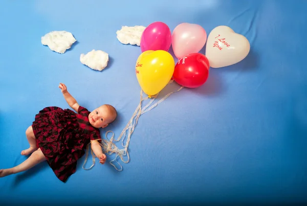 Dziecko leci na balony w chmury, leżąc na łóżku — Zdjęcie stockowe