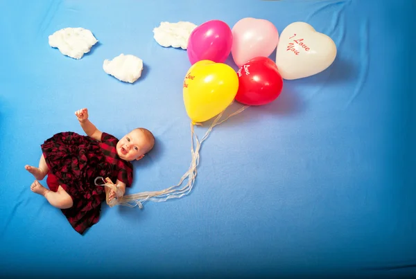Dziecko leci na balony w chmury, leżąc na łóżku — Zdjęcie stockowe
