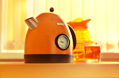 orange teapot on kitchen  table clipart