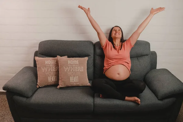Mujer Embarazada Sentada Sofá Levantando Los Brazos Felicidad Durante Concepto —  Fotos de Stock