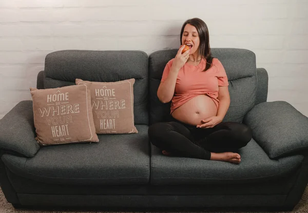 Mujer Embarazada Sentada Sofá Comiendo Una Manzana Concepto Buena Nutrición —  Fotos de Stock