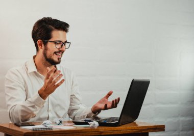 Gözlüklü Latin adam çalışıyor. Bilgisayarda bir video görüşmesi. Ev konseptinde çalış. Boşluğu kopyala.