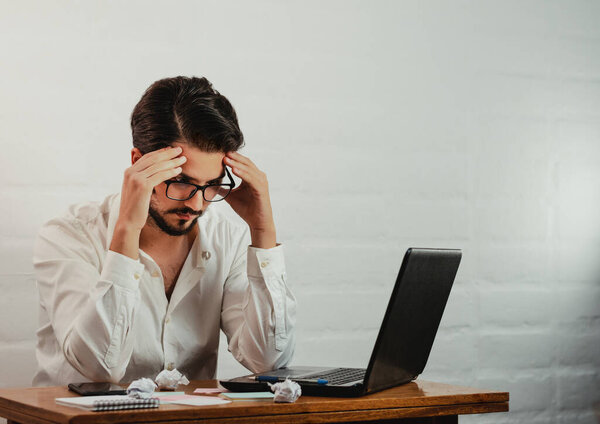 Latin man in glasses working. Gesture of stress and fatigue. Work at home concept. Copy space.