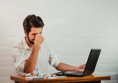 Ofisteki Latin adam, yorgunluk ve stres belirtileri gösteriyor. Elini yüzüne doğru uzatıyor. Ev konseptinde çalış. Boşluğu kopyala.