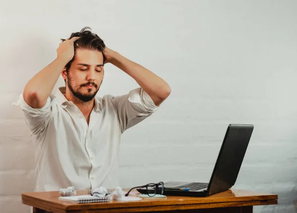 Ofisteki Latin adam, yorgunluk ve stres belirtileri gösteriyor. Elini başına koyup derin bir nefes alıyormuş. Ev konseptinde çalış. Boşluğu kopyala.