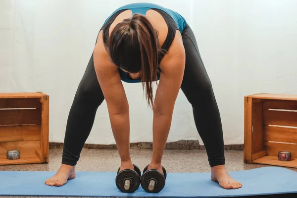 怀孕的拉丁女人举起哑铃 站在瑜伽垫上 健康和在家锻炼的概念 横向格式 — 图库照片