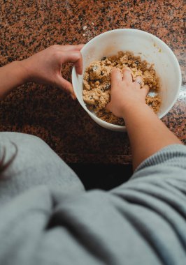Bir kadının elleriyle vurduğu yakın plan fotoğraf. Kurabiye olacak bir karışım. Sağlıklı ve ev yapımı gıda kavramı.